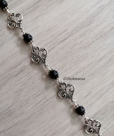 Bracelet with charms and black onyx beads. Black onyx is a stone of protection, it protects from the evil eye, it repels the presence of spirits who would try to influence you, it is very useful for mediums. It promotes a sense of responsibility and helps to maintain self-control by being more composed. Dimensions: 19 centimeters long and 1.3 centimeters wide If you want, I can add an extension chain. Materials used: zinc alloy and onyx (each natural stone being unique, they cannot be identical to the photography) This jewel will be delivered to you in a small organza pouch and sent by registered letter. To keep your jewelry in perfect condition, store them away from humidity and sunlight and avoid contact with water and perfume. Join me on: Instagram: https://www.instagram.com/darkmnesia Handmade Onyx Black Bracelets, Handmade Black Onyx Bracelets, Handmade Black Bohemian Charm Bracelet, Black Bohemian Bracelet Jewelry, Elegant Black Charm Bracelet For Gift, Elegant Black Rosary Bracelet, Handmade Black Spiritual Beaded Bracelets, Nickel-free Black Charm Bracelet As Gift, Handmade Black Metal Beaded Bracelets