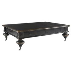 an old black coffee table with drawers on one end and two turned down legs at the bottom