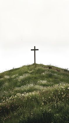 a cross on top of a grassy hill