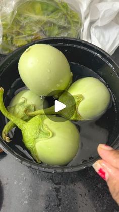 an image of some fruit in a bowl on the table with someone's hand