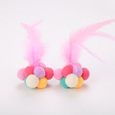 two pink and blue stuffed animals with feathers