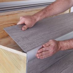 a man is working on wood flooring with his hands