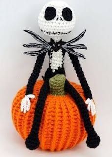 a crocheted skeleton sitting on top of a pumpkin