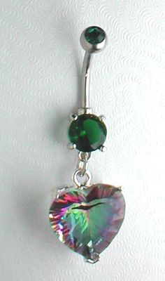 a heart shaped belly ring with green and pink crystals hanging from it's side