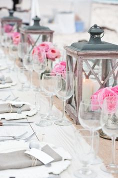 a long table is set with pink flowers and candles