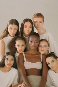 a group of models pose for the camera with their arms around each other in front of them