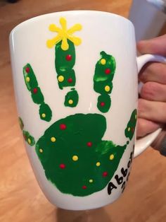 a person holding a coffee mug with handprints on it