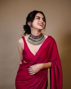 a woman wearing a red sari and smiling