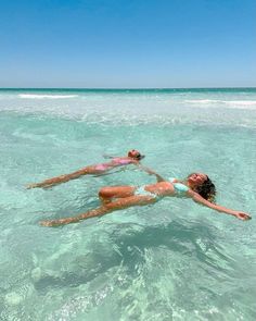 two women floating in the ocean on their stomachs