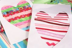 two heart shaped cards sitting next to each other on top of a table covered in paper