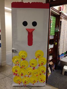 a door decorated to look like a turkey with many yellow ducks around it and a red nose