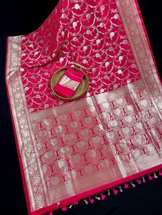 Luxurious Banarasi Semi Pure Mashru silk, renowned for its rich texture and lustrous sheen. The mashru weave combines the elegance of silk, ensuring a graceful drape that feels as good as it looks.  A true masterpiece that seamlessly blends traditional craftsmanship with contemporary flair. Featuring a rich Hot Pink Color, this saree is perfect for special occasions where you want to make a statement. Item : Saree Color : Hot Pink  Base Fabric : Handloom Banarasi Semi Pure Mashru Saree Blouse piece : Comes with Blouse piece Blouse material : Handloom Banarasi Mashru Saree Fall & Edging (Yes/No) : Yes Disclaimer -: - Color variation is possible due to various reasons like phone or desktop setting, resolution etc. Please don't hold us responsible. Our aim is to put the exact color of the Sar Hot Pink Color, Kantha Stitch, Blouse Material, Wine Colored, Handloom Saree, Rich Textures, Blouse Piece, Saree Blouse, Silk Saree