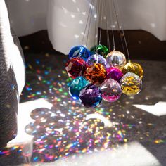 the sun shines brightly on colorful glass balls hanging from strings