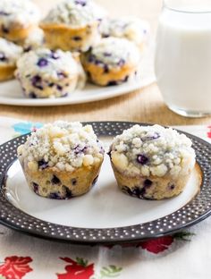 blueberry muffins on a plate next to a glass of milk