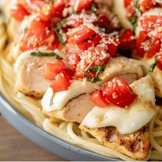 chicken with tomatoes and parmesan cheese on top of pasta