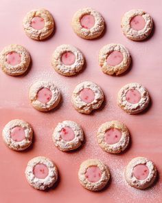 strawberry shortbread cookies with powdered sugar in the middle and pink icing on top