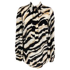 GUCCI long sleeve blouse comes in black and white animal print silk fabric with hidden placket and neck tie. Made in Italy.Excellent Pre-Owned Condition. Marked: 40 Measurements: Shoulder: 17 inches Bust: 40 inches Sleeve: 23 inches Length: 31 inches Reference: 117142 Category: Blouse More Details Brand: GUCCI Size: 4 Color: Beige Color 2: Black & White Fabric: Silk Pattern: Print Style: Hidden Placket Age Group: Adult Gender: Female Printed Silk Fabric, Black And White Top, Black And White Fabric, Black And White Tops, Fitted Trousers, Printed Silk, White Silk, Silk Top, Beige Color