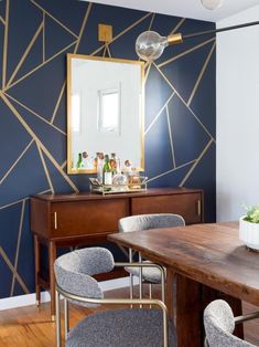 a dining room table with chairs and a mirror on the wall above it, next to a dresser