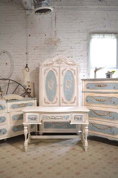 an old fashioned bedroom set with blue and white paint on the drawers, dressers and bed