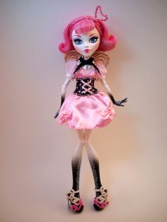 a doll with pink hair and blue eyes is standing on a white background wearing a dress