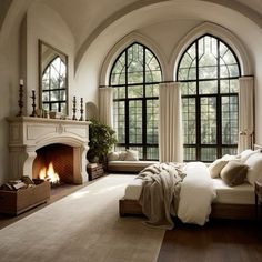 a large bedroom with arched windows and a fireplace