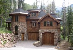 a large wooden house with two garages