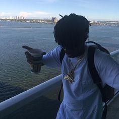 a man with dreadlocks holding a coffee cup