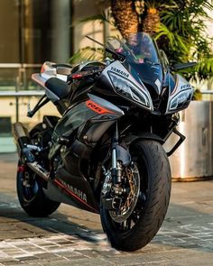 the motorcycle is parked on the side of the road in front of a planter