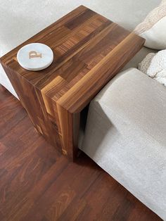 a wooden table sitting on top of a hard wood floor next to a white couch