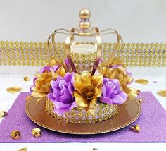 there is a gold crown with purple flowers on the plate next to some chocolates