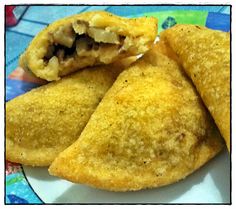 three fried pastries on a plate with a bite taken out of the top one