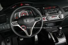 the interior of a car with steering wheel controls and dashboard lights, including an electronic display