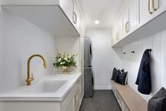 a kitchen with white cabinets and gold handles on the doors, along with a long counter