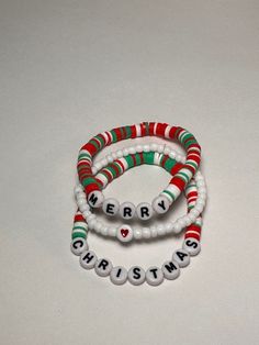 three beaded bracelets with the words merry christmas written in white and green beads