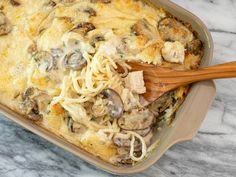 a casserole dish with pasta and mushrooms in it on a marble counter top