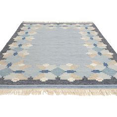 a blue and beige rug with fringes on the bottom, in front of a white background