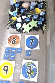 a plastic container filled with lots of different numbers and shapes on top of a table