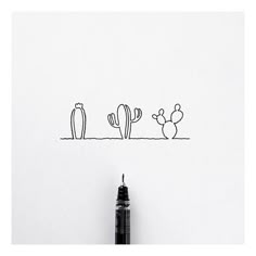 a pen is sitting next to a drawing of three cacti