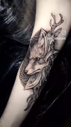 a black and white photo of a tattoo with a fox on it's arm