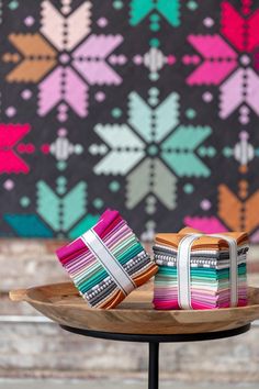 two colorful bags sitting on top of a wooden tray