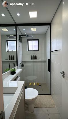 a bathroom with two sinks, a toilet and a shower stall in the middle of it