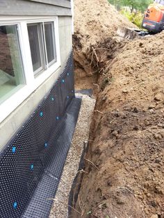 a house that has been dug in to the ground by a construction crew and workers