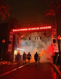 people walking under an archway at halloween horror nights