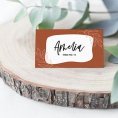 a place card sitting on top of a piece of wood