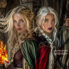 two beautiful blonde women dressed in medieval clothing holding torches and looking at the camera while standing next to each other