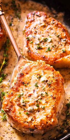 two pork chops are being cooked in a skillet with some herbs on top