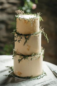 three tiered wedding cake with greenery on top