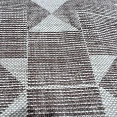 a brown and white checkered rug with an arrow pattern on the bottom half of it