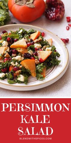 a white plate topped with kale salad next to tomatoes and pomegranates