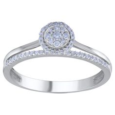 a white gold ring with diamonds on the band and an oval shaped diamond in the center